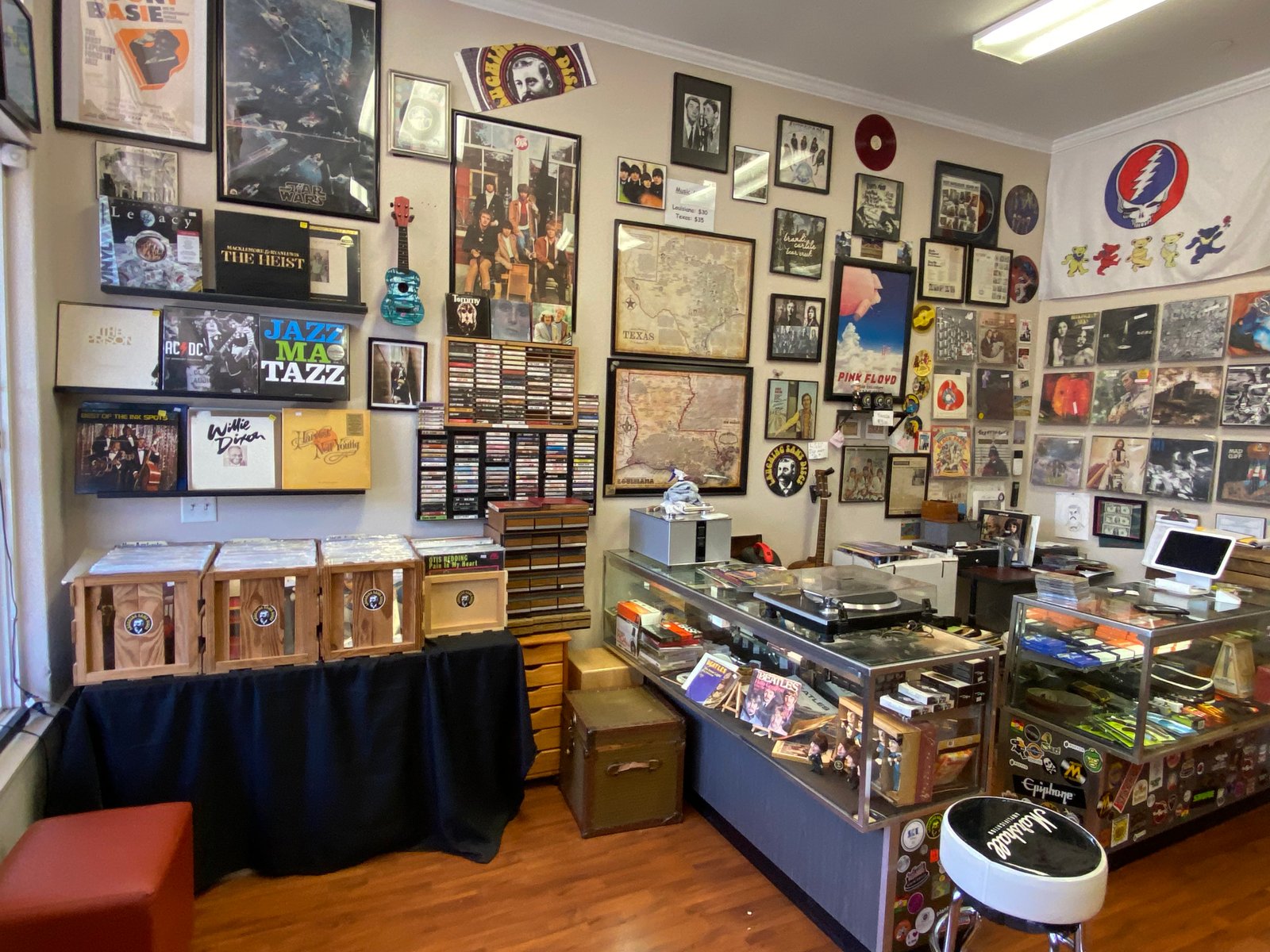 Vintage guitars, amps, and psychedelic concert posters on the brick wall at Laughing Sam's